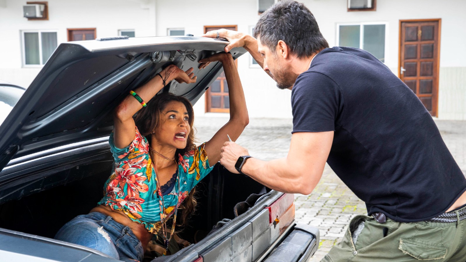 Brisa (Lucy Alves) se esconde no porta-malas do carro de Oto (Romulo Estrela)
