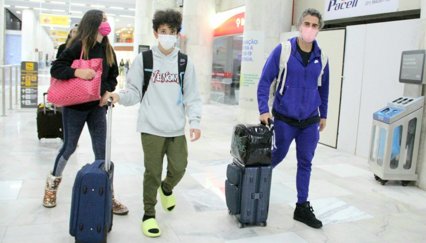Marcos Mion em aeroporto com os filhos