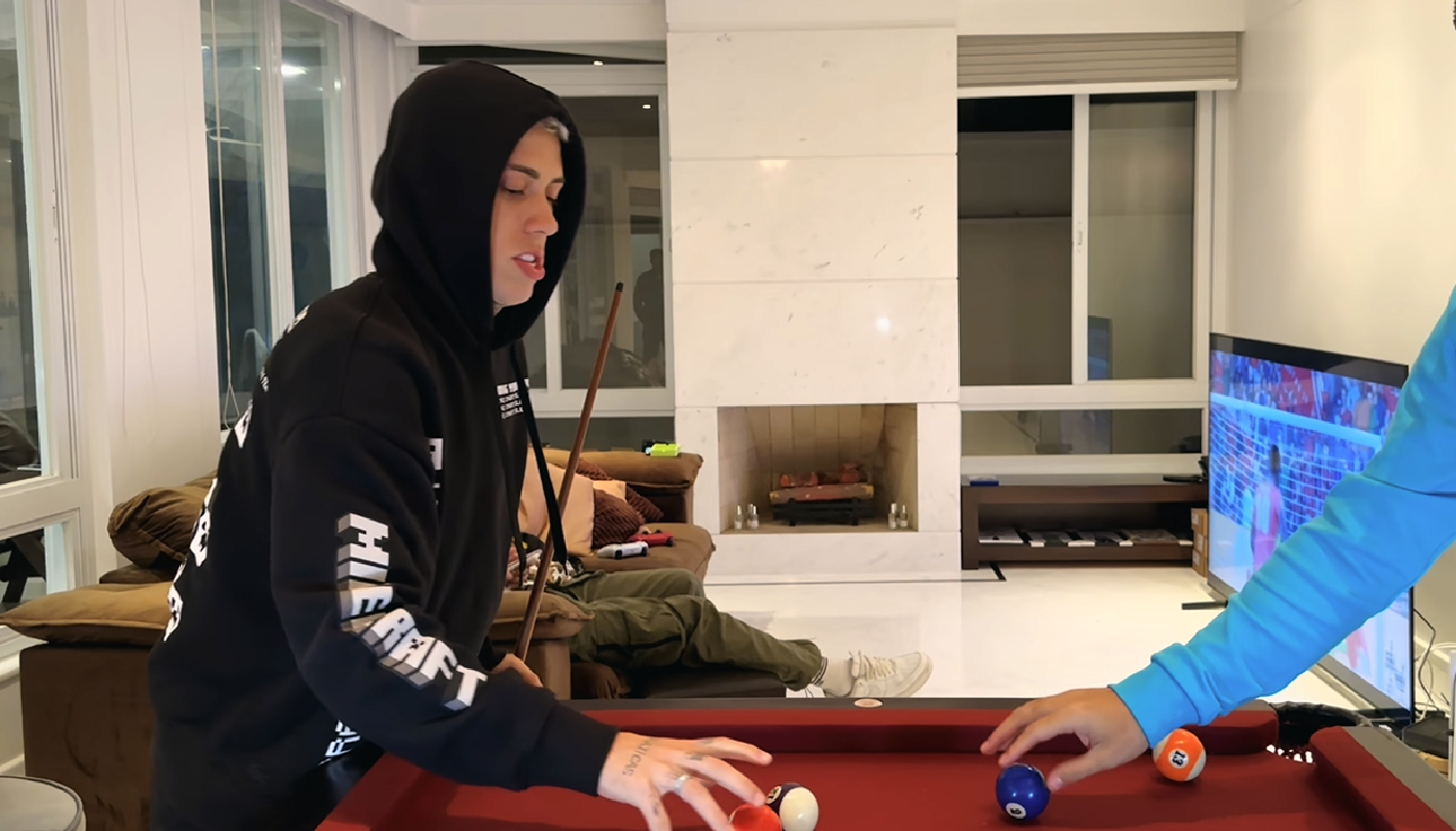 Sala da mansão, com lareira e janelas de vidro