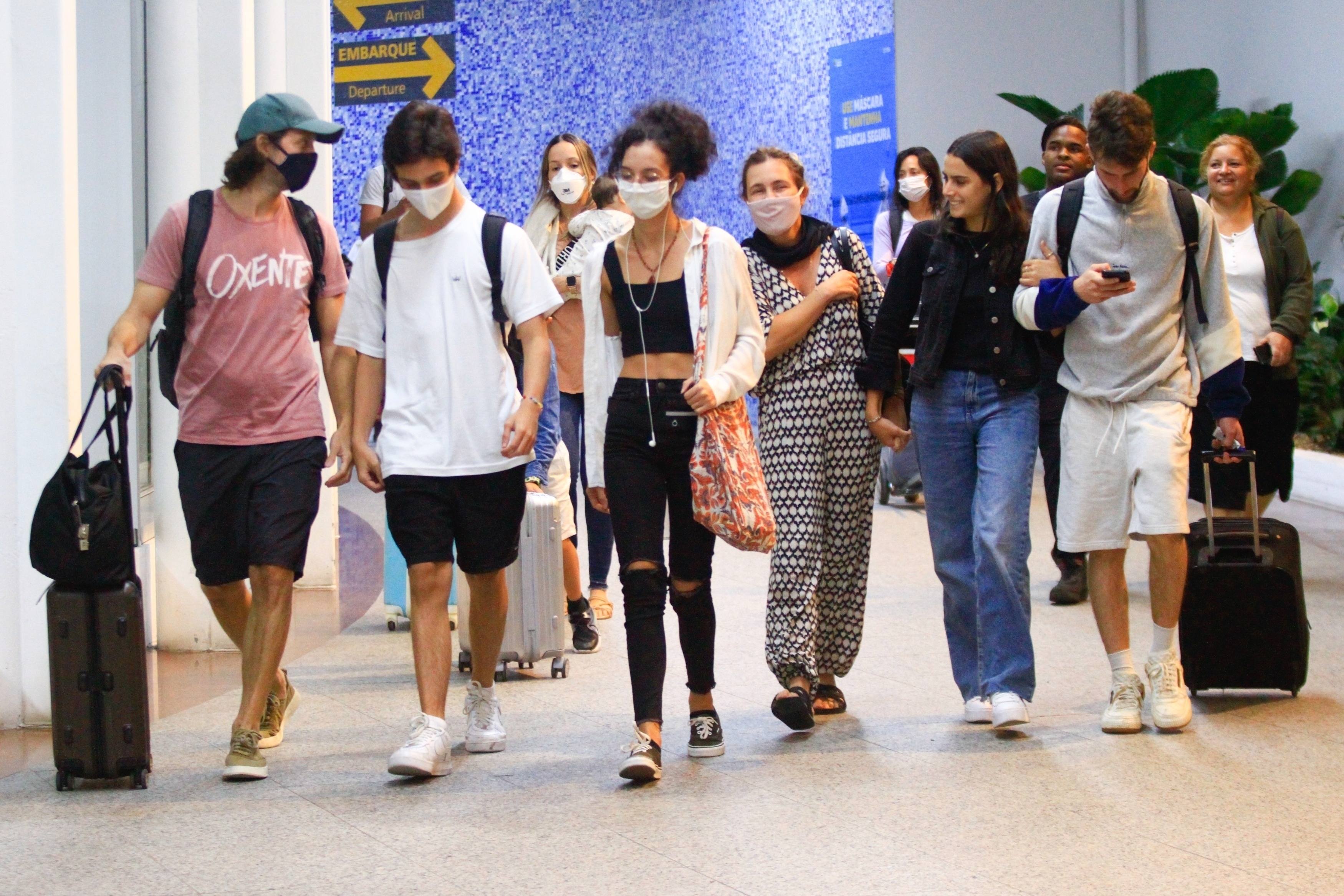 Adriana Esteves e Vladimir Brichta desembarcam com seus filhos no aeroporto.